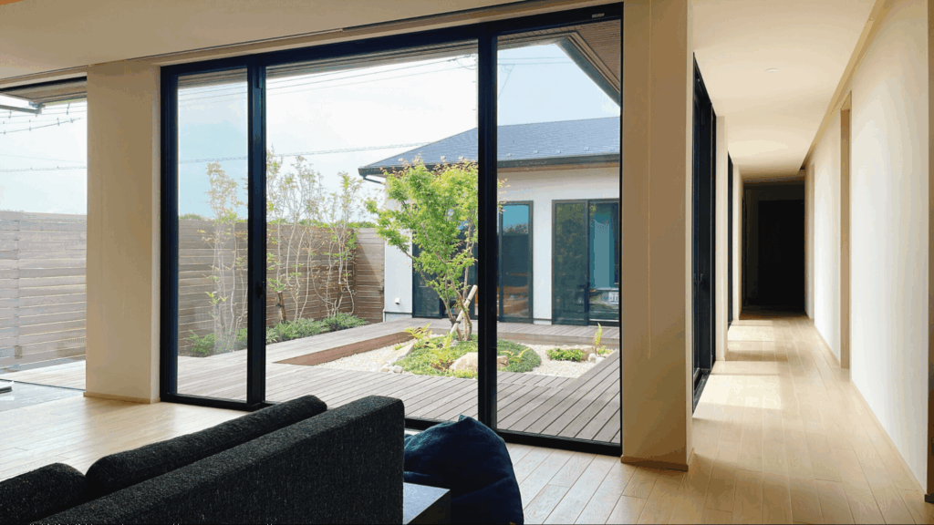 リビングと庭、ガレージがつながる動線が特徴で、夕暮れにはライトアップされた植栽と愛車が絵画のような景色