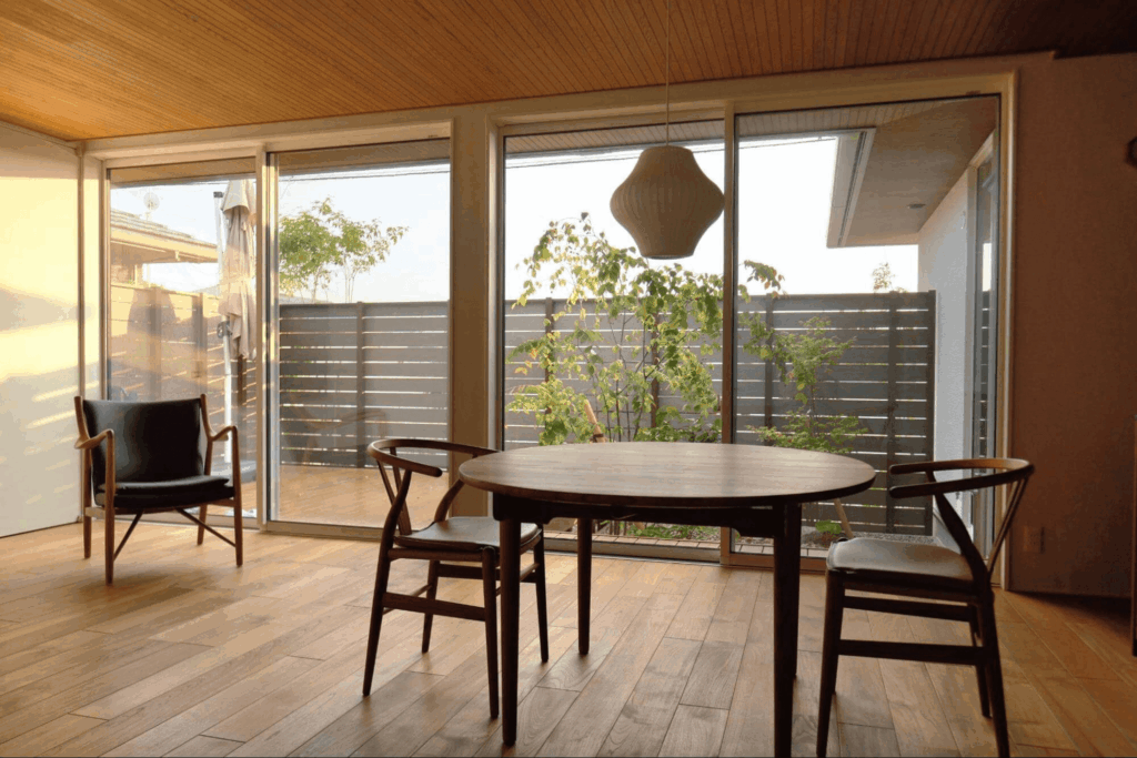 庭とリビングのつながりがゆるやかで、内装の木の気配と庭の緑が心地よく溶け合う空間